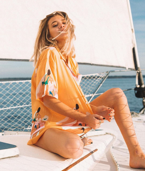 Blonde girl on a sailboat with a Duvin casual woven. MFG Merch